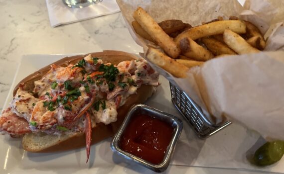 Lobster roll and french fries on a bar in a restaurant