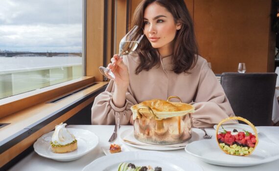 Woman sipping wine and dining on a luxury cruise ship.