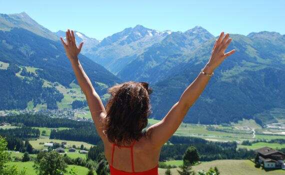 Woman with her hands raised looking out at mountains