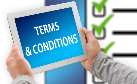Hands holding a tablet that has "Terms & Conditions" displayed