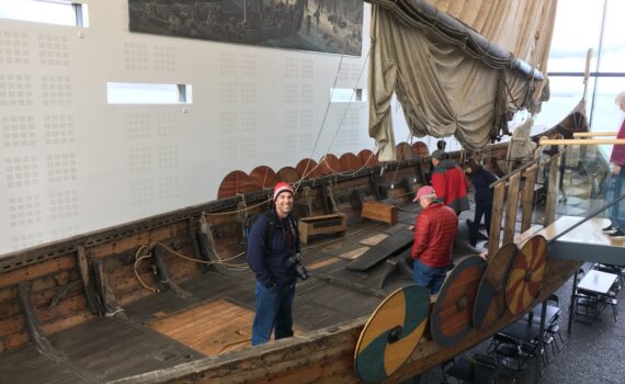 A man standing in a replica of a Viking Ship at the Viking World Museum. A top day trip from Reykjavik