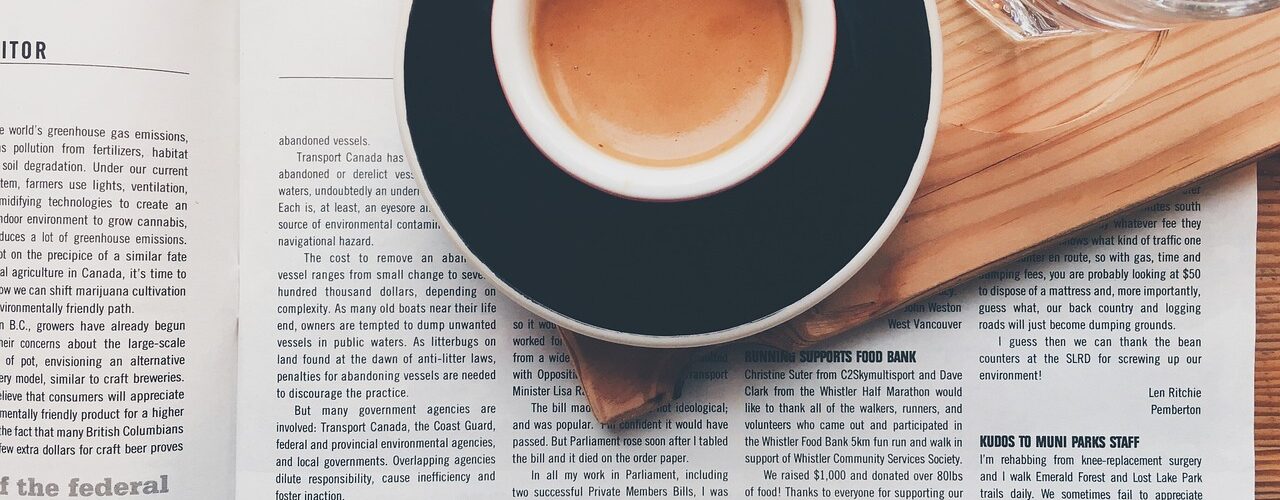 A cup of coffee on an opened magazine - press coverage