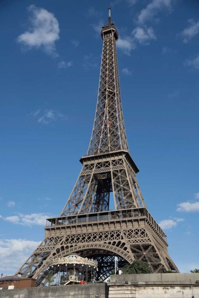 Visiting Paris France you will want to visit the Eiffel Tower. Seen here against a blue sky, a view from below on the water