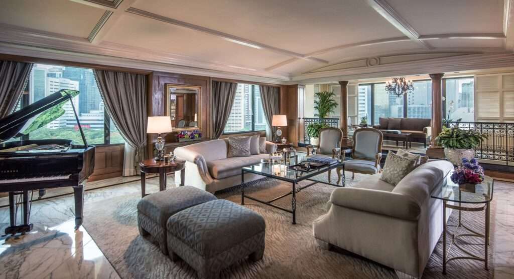 The living room in a top suite at The Peninsula Manila. Room adorned with grand piano and luxurious chairs and sofas