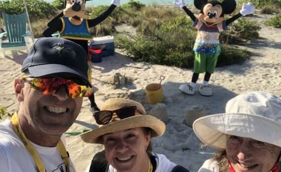 3 Travelers from different generations on Castaway Cay - Disney's Island -- With Mickey and Goofy behind them