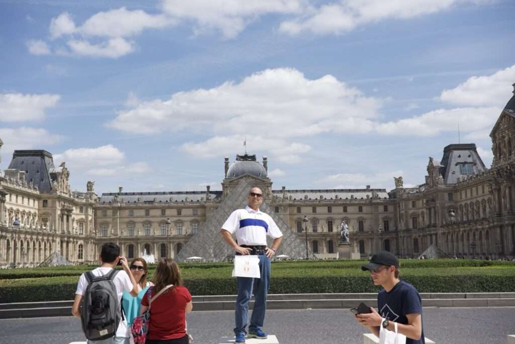 Man standing outside of the Louvre Museum in Paris