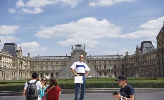 Man standing outside of the Louvre Museum in Paris