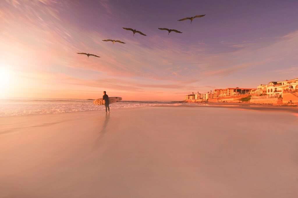 Sunset over the ocean on a beach in front of a hotel