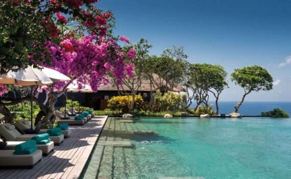 Pool at Bulgari resort bali, flower trees and views of the Indian Ocean