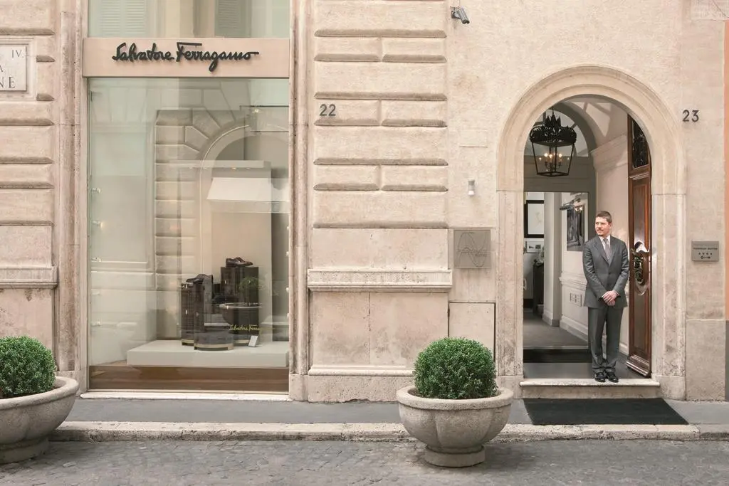 Portrait Roma Entrance with a man standing in. the doorway - this is a luxury hotel in Rome