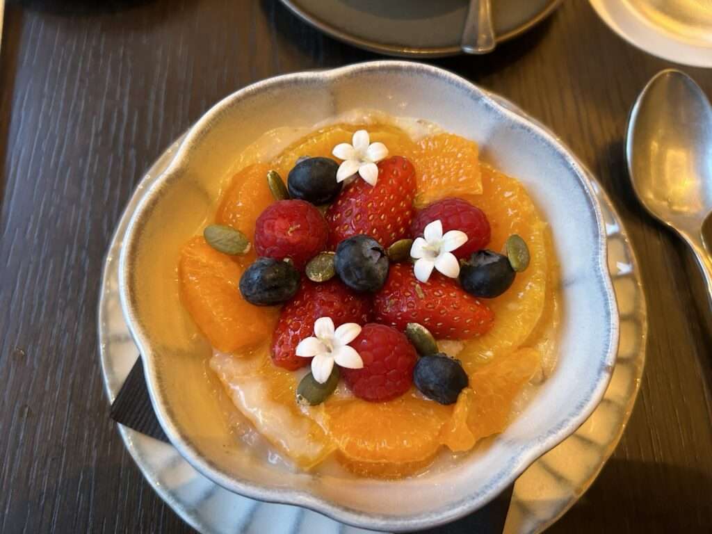 Breakfast at La Pristine - a bowl of rice porridge with fresh fruit and edible flowers