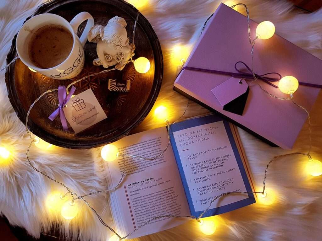 Hygge part of the culture in Denmark - pictured here a book, coffee and soft lighting