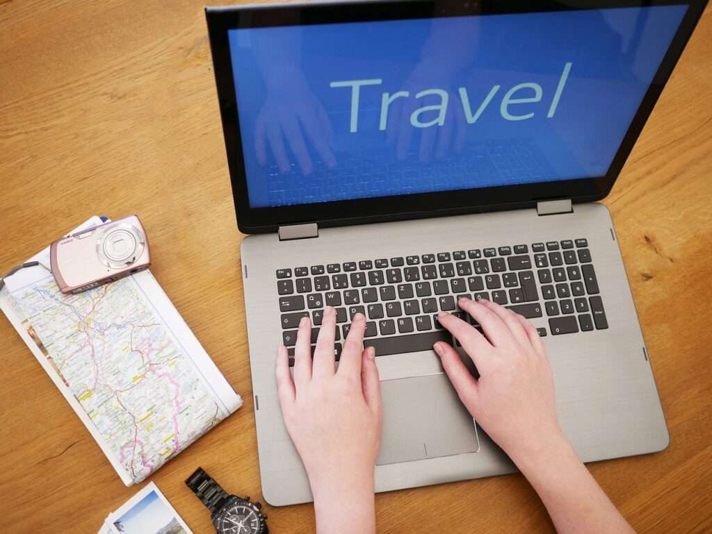 A computer with the word "Travel" depicting travelers booking their vacations and holidays online