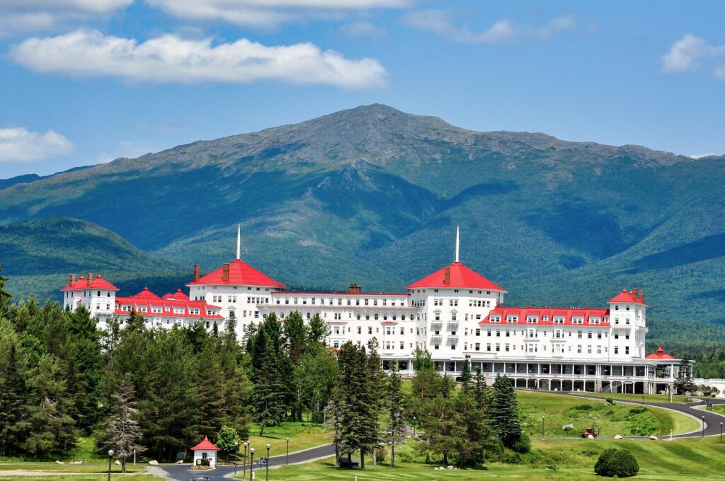 Mount Washington Hotel in New Hampshire. White hotel with red roof against the backdrop of Mount Washington.