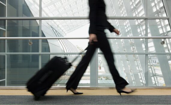 Woman walking through the airport with a small carry on bag - light packing for 2 weeks in Europe.